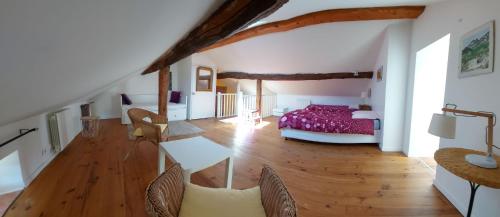 a bedroom with a bed and a wooden floor at La Bruyère - chez Martine in Appy