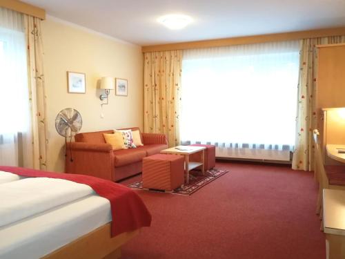 une chambre d'hôtel avec un lit et un canapé dans l'établissement Pension Katrin, à Salzbourg