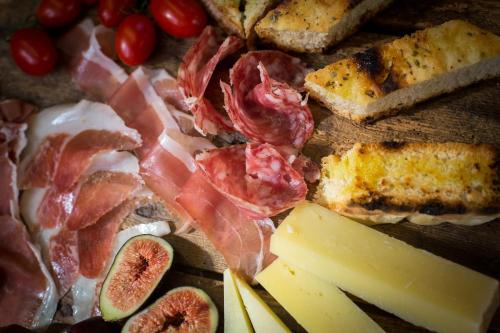 a table topped with meats and cheese and other foods at Locanda Dell'Oleificio in Mezzane di Sotto