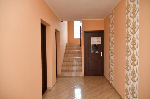 a hallway with a door and stairs in a house at Kelemen Vendégház 2 in Praid