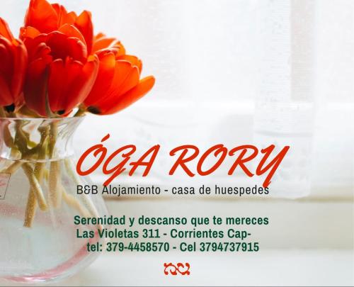 a vase of red flowers in a window at Óga Rory in Corrientes