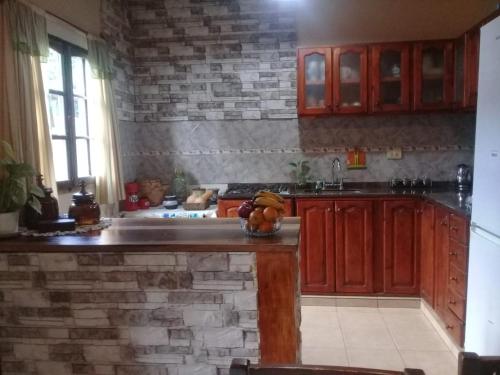 a kitchen with wooden cabinets and a stone wall at Óga Rory in Corrientes