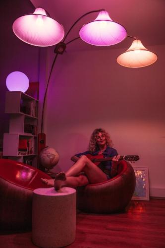 a woman sitting in a chair with a guitar in a room at STAY OPEN Venice Beach in Los Angeles