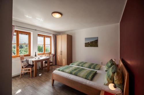 ヴァイセンキルヒェン・イン・デア・ヴァッハウにあるWinzerhof & Gästehaus Bernhardのベッドルーム1室(ベッド1台、デスク、テーブル付)