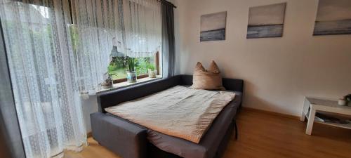 un sofá con una almohada delante de una ventana en Hafenliebe en List