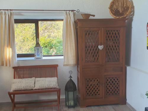 a room with a wooden cabinet and a bench and a window at Casa el Porte in Tegueste