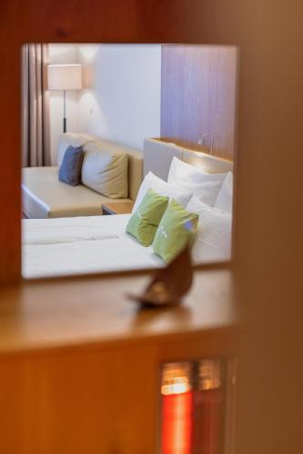 a reflection of a hotel room with a bed and a couch at m3Hotel in Sankt Anton am Arlberg