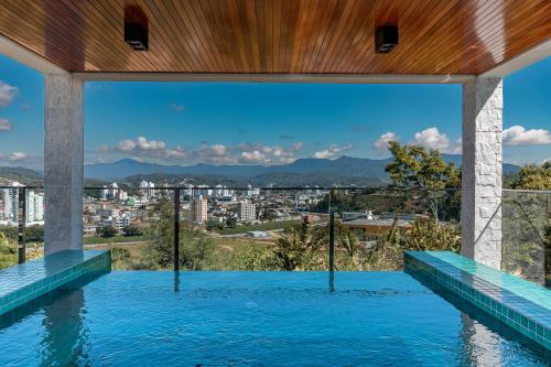 a swimming pool with a view of a city at Monthez Hotel & Eventos in Brusque