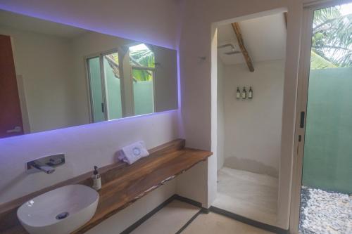 a bathroom with a sink and a mirror at Hotel Circulo Bacalar in Bacalar
