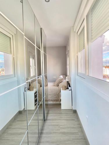 a bedroom with a bed and a glass wall at Luxury Attics Avenida Italia PARKING INCLUIDO in Huelva