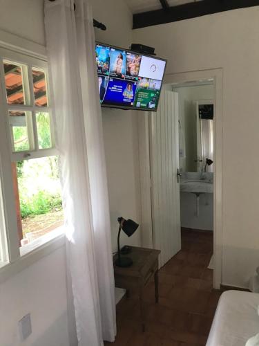 a living room with a television on the wall at Canyon Cascata Eco Parque in Capitólio