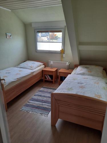 two beds in a small room with a window at Ferienwohnung Luise Blum in Steffeln