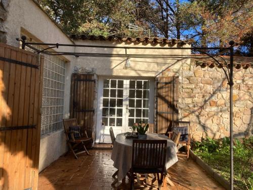 a patio with a table and chairs and a building at Gîte Encore Un Soir in Hyères