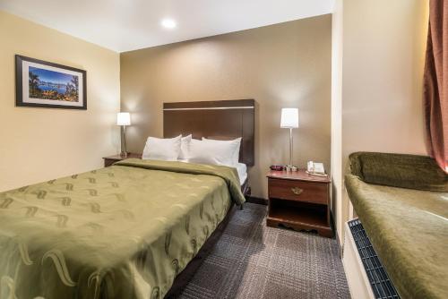 a small hotel room with a bed and a night stand at Quality Inn & Suites near NAS Fallon in Fallon