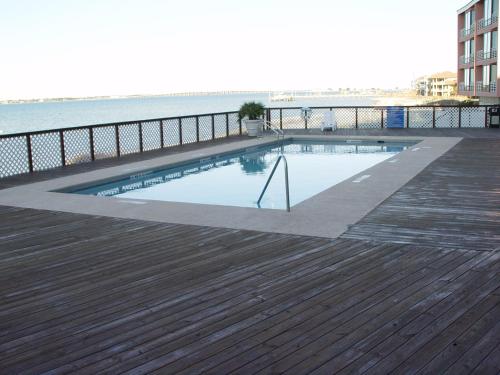 a swimming pool on a deck next to the water at Beautiful Beach Condo in Pensacola Beach