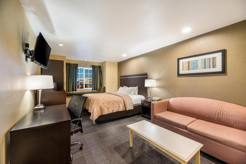 a hotel room with a bed and a couch at Quality Inn & Suites near NAS Fallon in Fallon