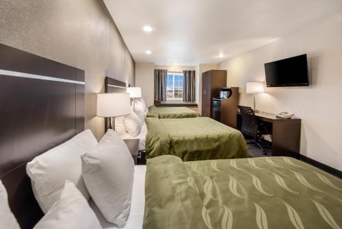 a hotel room with two beds and a desk at Quality Inn & Suites near NAS Fallon in Fallon