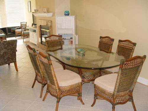a dining room with a glass table and chairs at Beautiful Beach Condo in Pensacola Beach