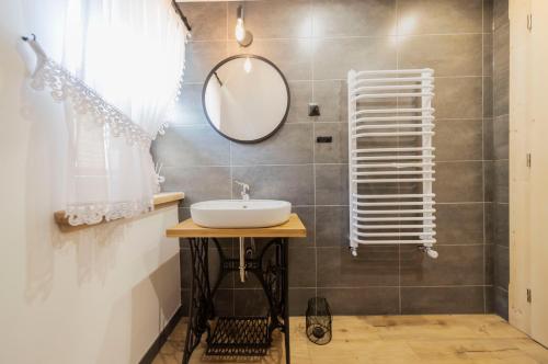 a bathroom with a sink and a mirror at Atelier Jana Kasprowicza SAUNA&JACUZZI in Poronin