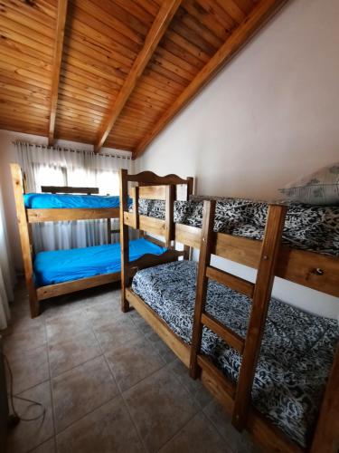 a room with three bunk beds in a house at MarraHOME in El Challao