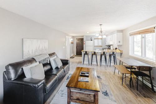 a living room with a black leather couch and a table at Beaver Village 15-11 in Winter Park