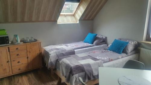a room with two beds and a couch and a window at Pokoje Gościnne Kacper Blisko Gondoli in Szczyrk