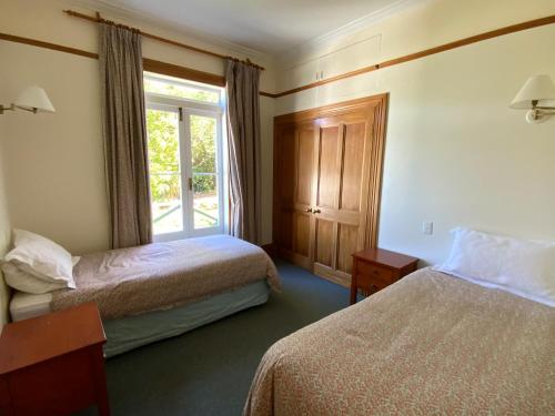 a hotel room with two beds and a window at Glenfern Sanctuary in Port Fitzroy