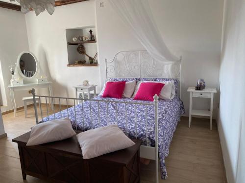 een slaapkamer met een bed met roze en paarse kussens bij La Casa di Bianca in Calcata