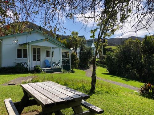 a wooden picnic table in front of a house at Glenfern Sanctuary in Port Fitzroy