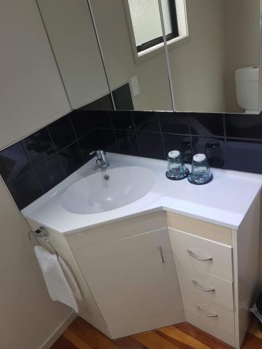 a bathroom with a white sink and a mirror at Waihi Beach Paradise Resort in Waihi Beach