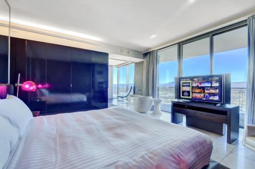 Private Luxury Panoramic Suite at Palms Place في لاس فيغاس: غرفة نوم بسرير كبير وتلفزيون بشاشة مسطحة