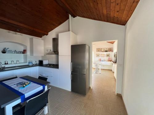a kitchen with a refrigerator and a table in it at Appartamento La Serra di Angela a Lerici in Lerici