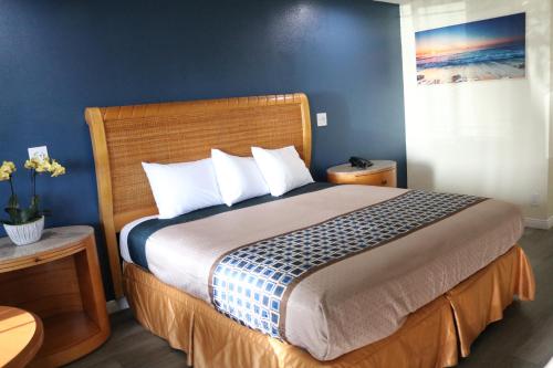 a bedroom with a large bed with blue walls at Valli Hi Motel in San Ysidro, San Diego