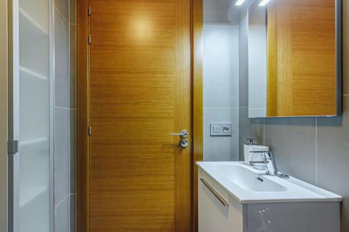 a bathroom with a sink and a wooden door at El Medano, La Tejita in El Médano