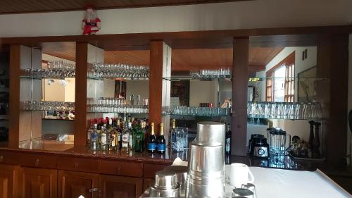 a bar with a lot of bottles and glasses at Hotel Girassol in Penedo