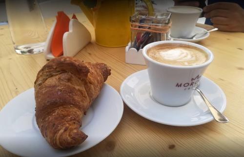 a plate with a croissant and a cup of coffee at La Casa di Vale in Martina Franca