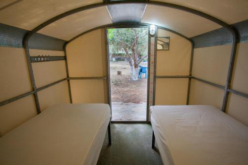 two beds in a room with an open door at Camping Koula in Parikia