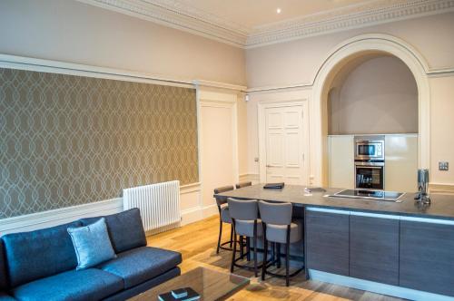 a living room with a couch and a kitchen at Dreamhouse at Blythswood Apartments Glasgow in Glasgow