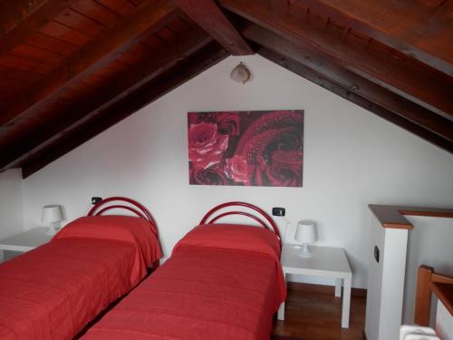 two beds in a room with a painting on the wall at My Bellagio Home in Bellagio