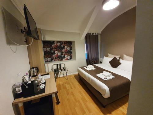 a hotel room with a large bed and a table at DOMUS FIESCHI Rooms self check in in Genova