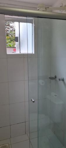 a glass shower in a bathroom with a window at Lacqua diRoma 1 - Apartamentos JN in Caldas Novas