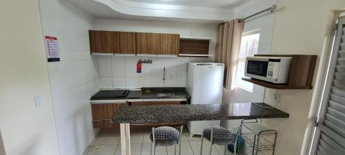 a small kitchen with a counter and a refrigerator at Lacqua diRoma 1 - Apartamentos JN in Caldas Novas