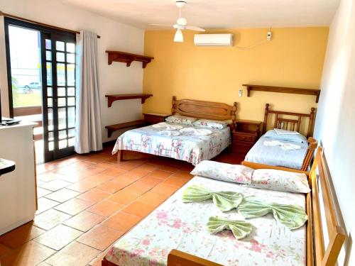 a room with three beds in a room at Pousada Do Farol in Capão da Canoa