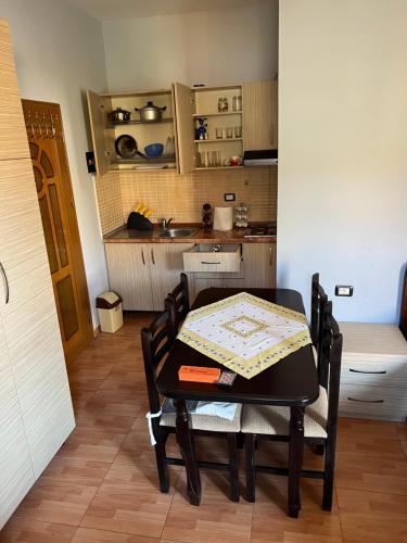 a table and chairs with a kitchen in the background at Gazi’s Apartament for Rent in Golem