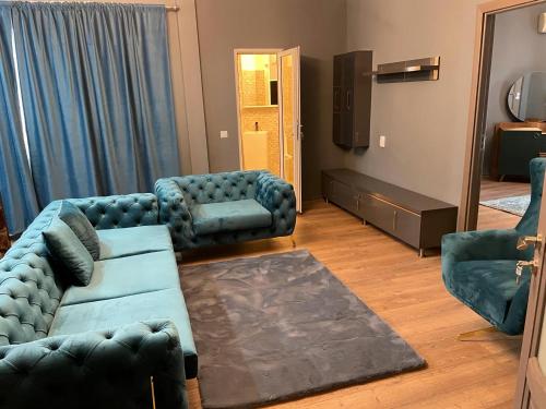 Una sala de estar con un sofá y sillas y un televisor. en BalcescuSuite, en Bucarest