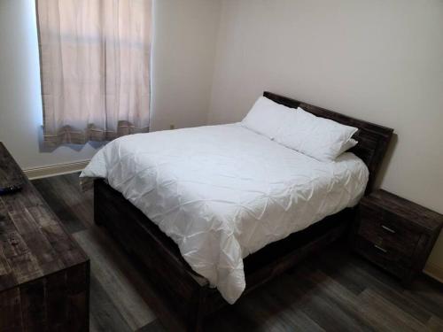 a bedroom with a bed with white sheets and a window at Chateau 18 in Hammond