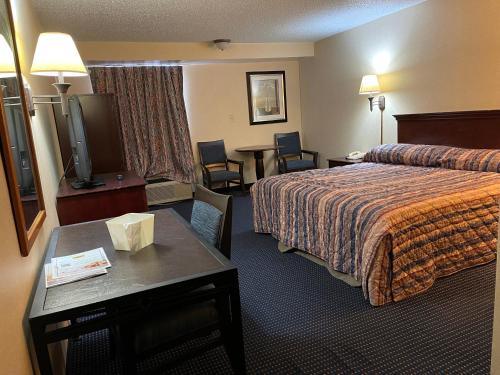 a hotel room with a bed and a table at Budget Inn Temple Hills in Temple Hills