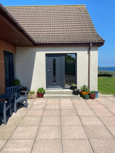 a house with a blue door and a patio at Aultnagar Accommodation in Orkney