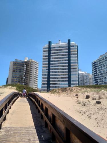 un pont sur la plage avec des bâtiments en arrière-plan dans l'établissement Apartamento Estrella de Mar, à Punta del Este