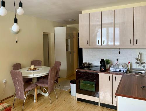 a kitchen with a table and a small table and a table and chairs at Ski-in & Ski-out, Apartman Filip - 30m from GONDOLA Brzeće in Kopaonik